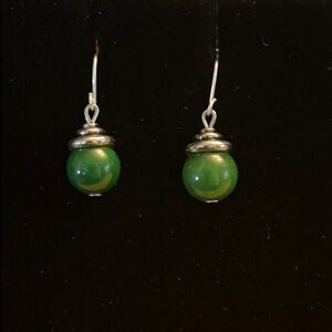 Handcrafted silver tone earrings with green bead.
